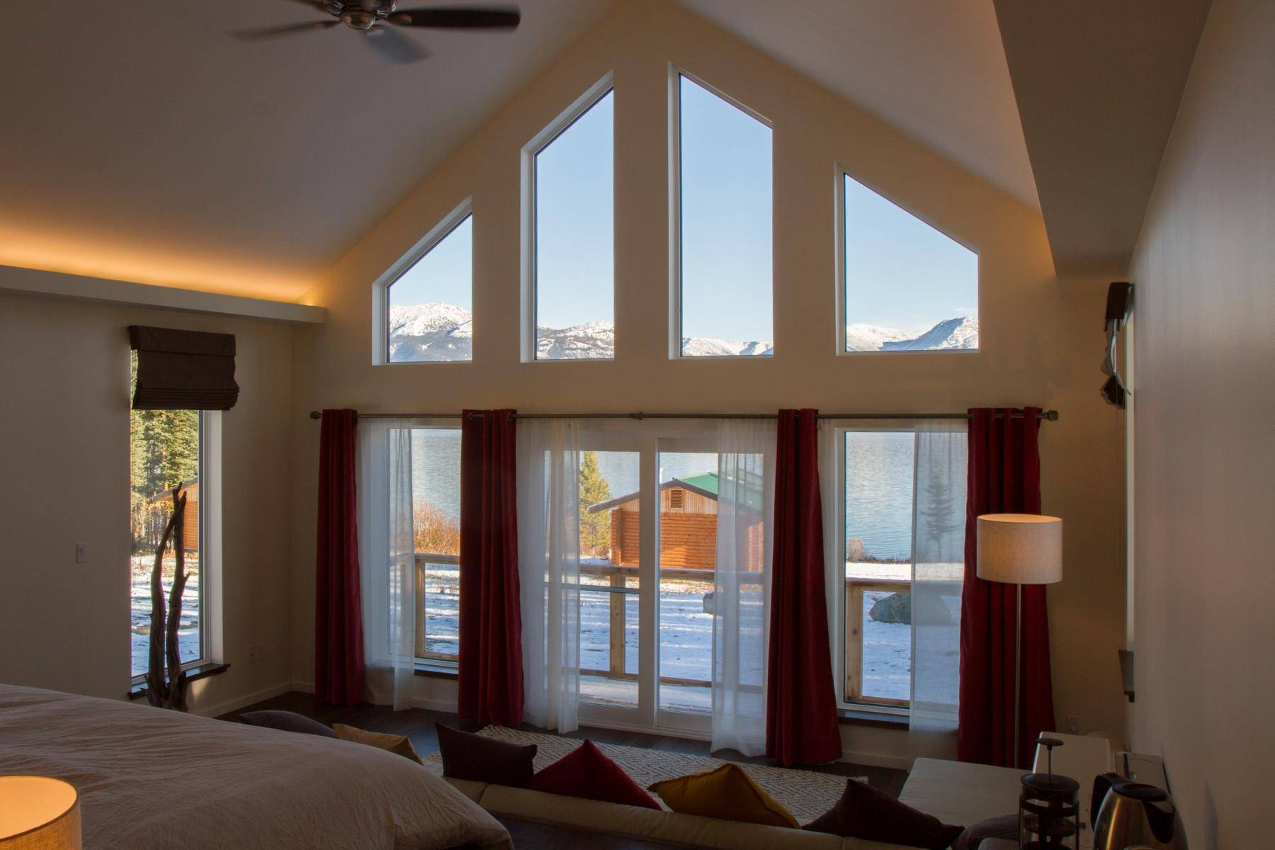 Deluxe villa interior showing the view outisde the panorama window to the lake and mountains