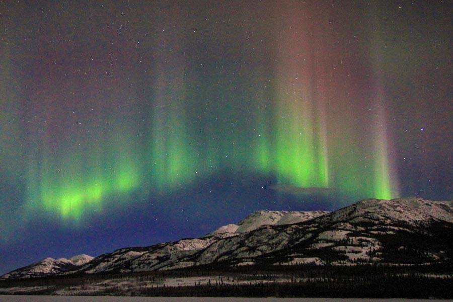 Aurora borealis in the sky over some mountains