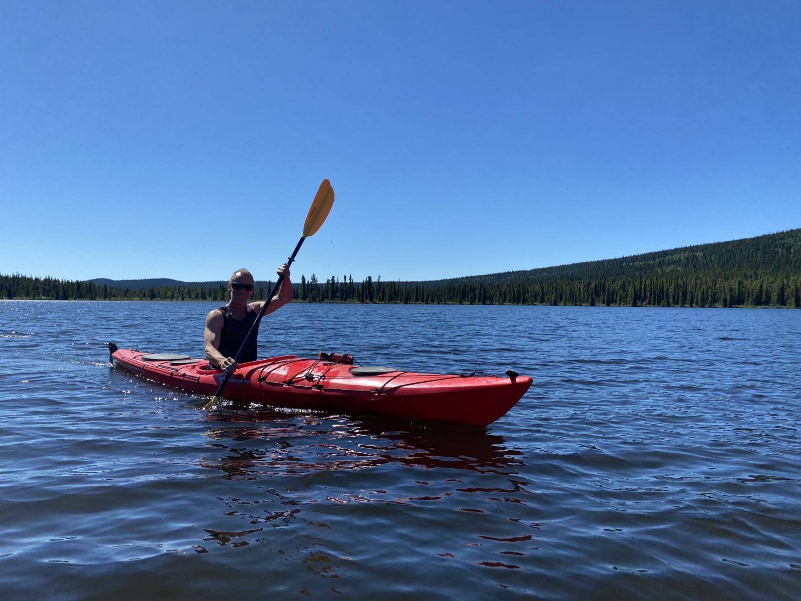 man paddling kayak on lake