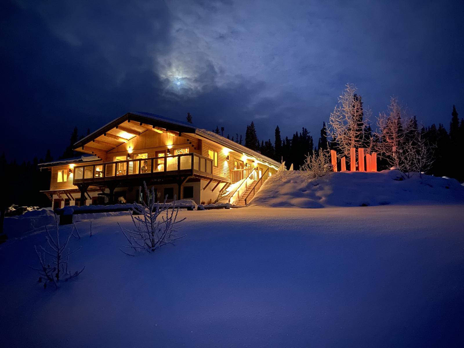 Restaurant lit at night, moon over it, deep snow
